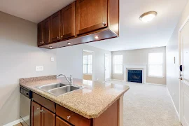 Kitchen with custom wood cabinets looking into the living room with fireplace