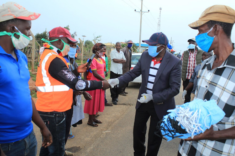 Mwingi North MP Paul Nzengu distributes masks to boda boda riders.