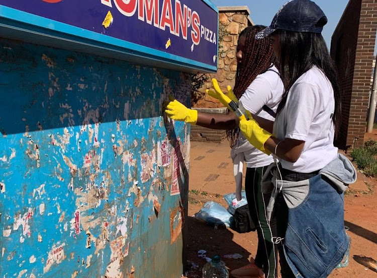 Activists remove flyers promoting 'unsafe abortions' in the Johannesburg CBD on Thursday.