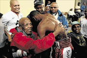 EMOTIONAL MEETING: IBO junior featherweight champion Thabo Sonjica gets a warm embrace from his ailing promoter, Mzi Mnguni 
      photo: MICHAEL PINYANA