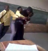 Pupils manhandling teacher. 