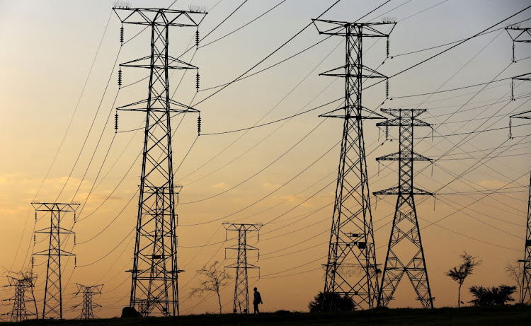 A man walks beneath electricity pylons in Orlando, Soweto. Picture: SIPHIWE SIBEKO/REUTERS