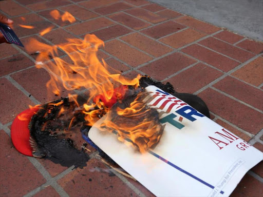 Anti-Trump demonstrators burn Donald Trump's campaign items outside a campaign event in San Diego, California US in May 27, 2016. Photo/Reuters