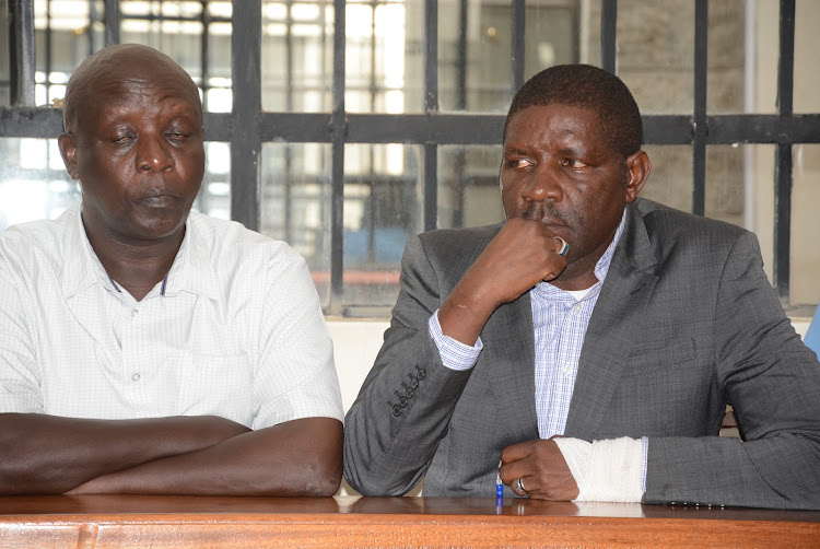 Nakuru East MCA Humphrey Mwaniki and Nakuru Town East MP David Gikaria follow proceedings at Naivasha law courts