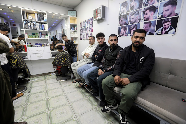 Abdullah Mahmoud, 21, an Iraqi Kurdish man, who plans to travel to Minsk in hope to reach the European Union this month, sits in a barber shop in city of Said Sadiq, in Sulaimaniya province, Iraq November 11 2021. Picture taken November 11, 2021. Picture: REUTERS/AKO RASHEED