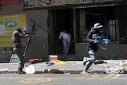 Human Rights Watch says SA's five-year national action plan to combat xenophobia and other crimes, while an important step, fails to address the lack of accountability for xenophobic crimes and has no clear implementation strategy. In this 2019 photograph, police take on looters in Katlehong during a wave of attacks on foreign-owned shops. 