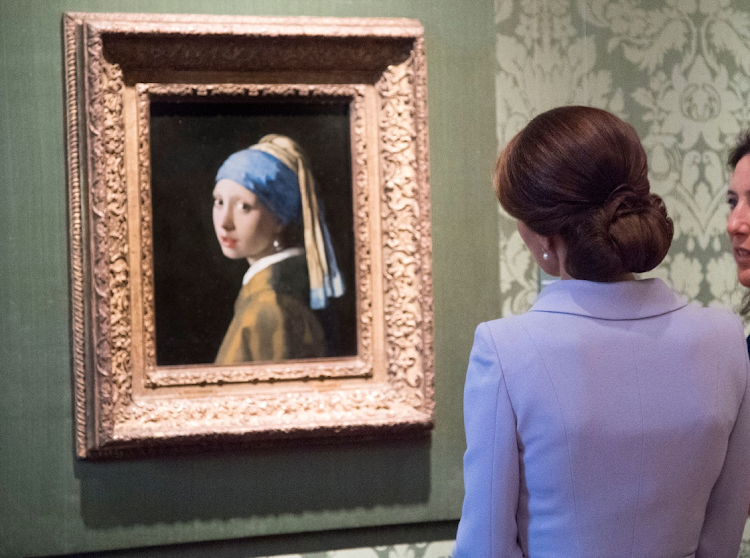 Britain's Kate, the Duchess of Cambridge, views 'Girl with a Pearl Earring' by Johannes Vermeer during a visit to the Mauritshuis in The Hague, Netherlands, on October 11 2016. A climate activist glued his head to glass covering the world-famous painting on Thursday. File photo.