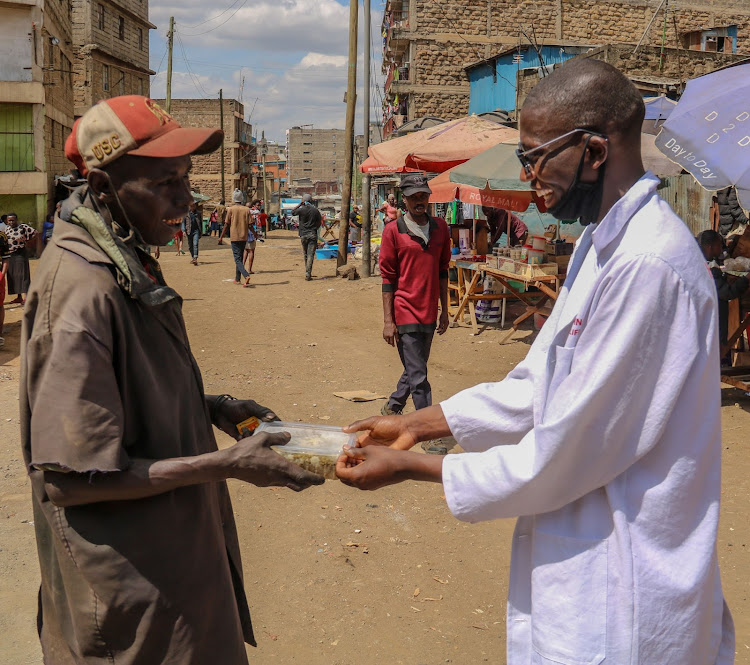 John Ngaroiya receives food from Kimathi Maragu