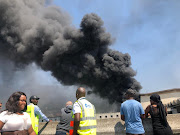 Thick smoke billows from the Cape Town train station where two trains were set alight on October 9 2018. 