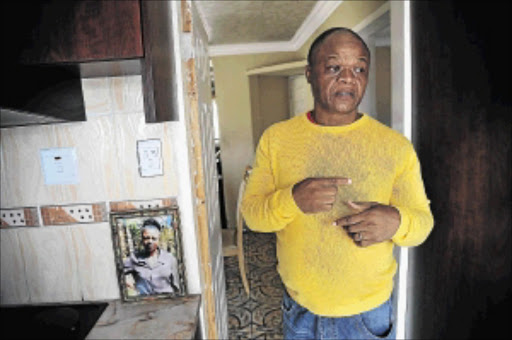 NOT SATISFIED: Lwandle Mkhulisi with a picture of his sister Phumzile, who died in the Nigerian church collapse last year, at his home in Wattville on the East Rand PHOTO: Veli Nhlapo