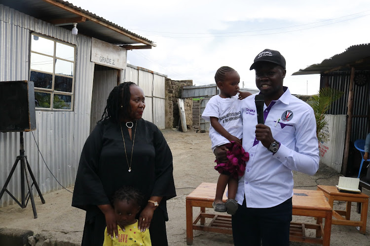 Nuru children home director Florence Mbithe with Ochaka Suits House Ltd CEO Harrison Ochaka displaying his products at Nuru children home in Athi River, Machakos County on May 13, 2024.