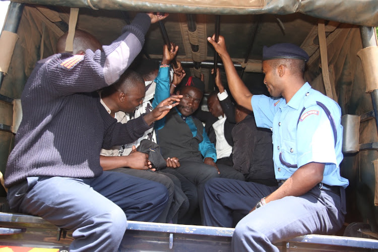 Police officers ferry the 22 youths arrested for allegedly planning to disrupt a meeting to Kandara police station.