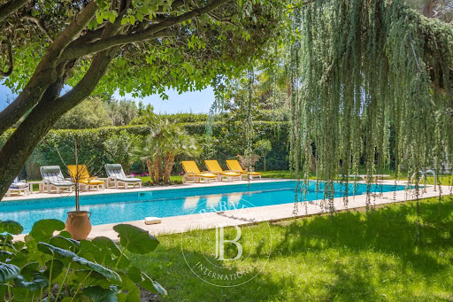 Swimming pool with loungers and lush garden in this luxury villa for seasonal rental in Cannes (350 m²)