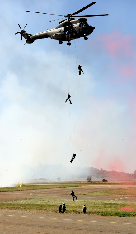 Soldiers scale down a rope out of a Puma during the South African Air Force Museum Airshow held at the Swartkop air force base in Pretoria, on May 5, 2018.