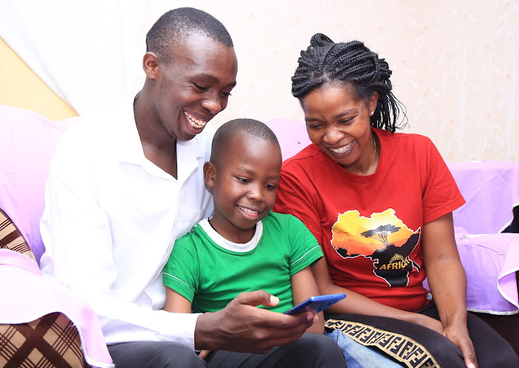 A family use a smart phone to help their son read