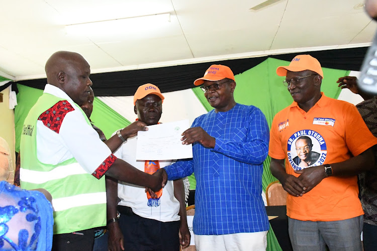 Former Funyula MP Paul Otuoma receives his clearance certificate from Busia IEBC chief Lazarus Chebii on Sunday, June 5, 2022. Looking on is his running mate Arthur Odera.