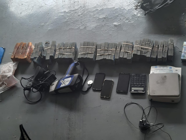Bundles of cash, cellphones and a diamond tester were among the items recovered.