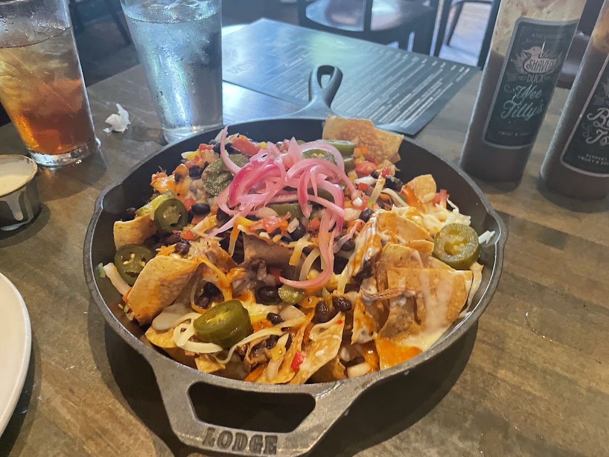 Nachos with cheese sauce, pickled onions, smoked pork, and more!