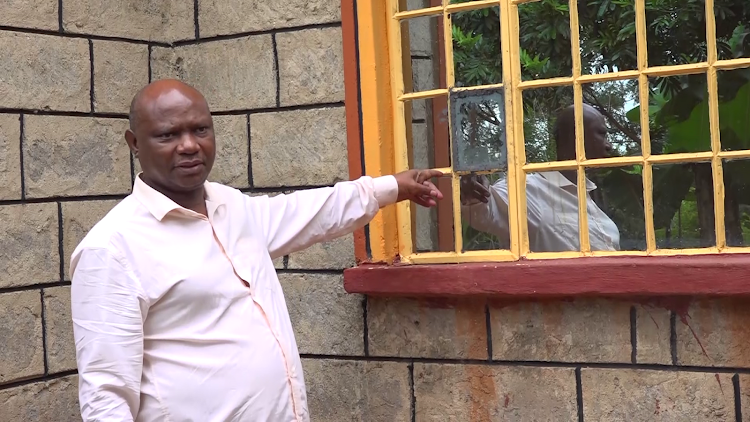 Mwangi Kamau, a resident of Kamuiru village pointing to a freshly repaired window pane that was destroyed by the burglar last week.