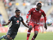 Katlego Mkhabela of Sekhukhune United is challenged by Monnapule Saleng of Orlando Pirates during their DStv Premiership match at Orlando Stadium.