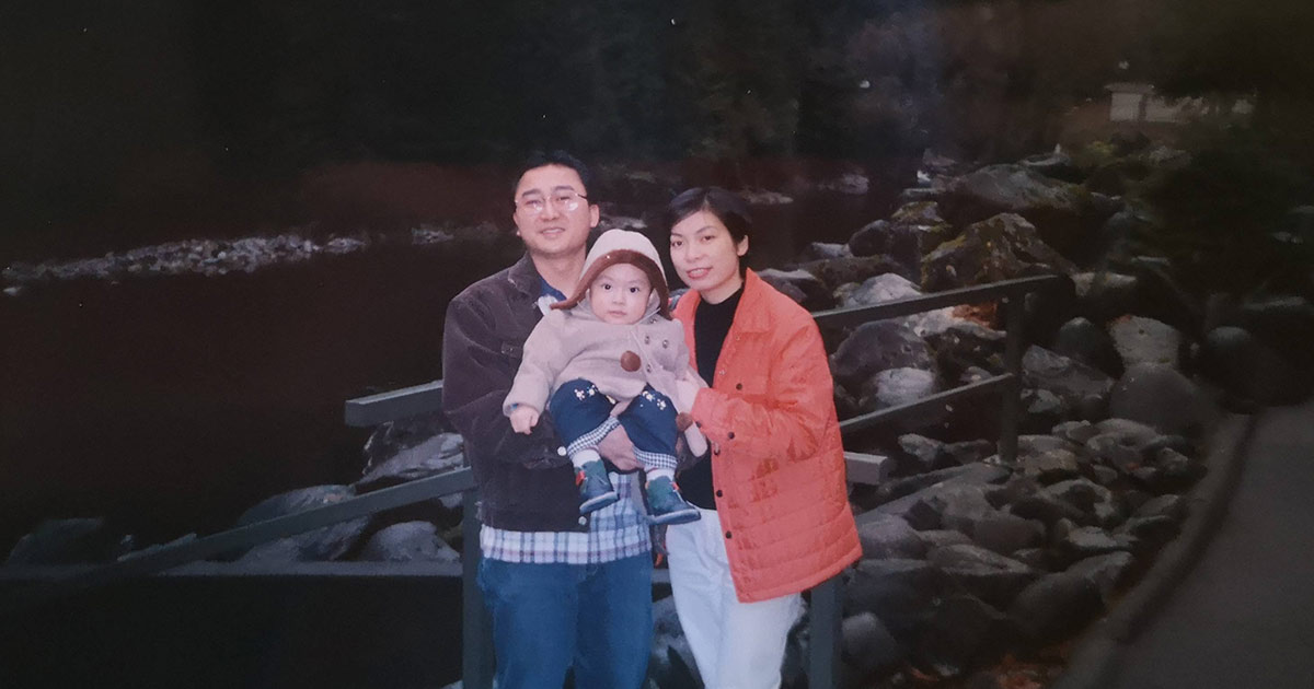 Mother, father, and young son standing next to a river in Canada.