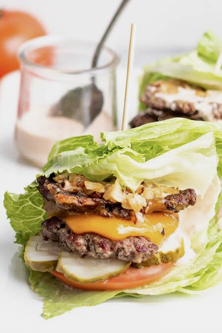 Lettuce burger stuffed with prickles, cheese, fried onions, tomato slices, beef patties and cheese.