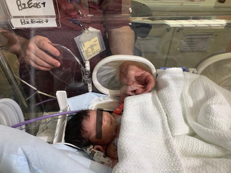 Dr Timothy Hardcastle from Chief Albert Luthuli hospital in Durban with the baby who was rescued from a stormwater drain on Monday.