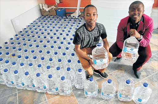 WATER-TIGHT: Mthatha-based entrepreneurs Kanya Mngqibisa, 16, and Thando Phantsi, 17, pictured at their own bottled water company, AquaTK Picture: LULAMILE FENI