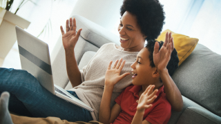 woman and young boy play together with hands up