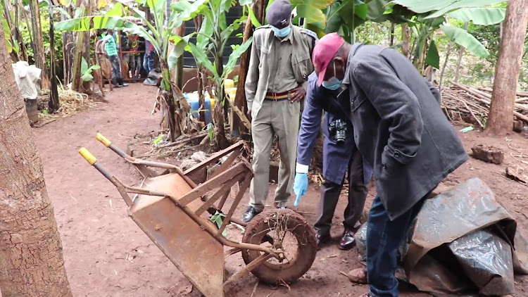 Police officers at the scene where the body of Anthony Macharia was found buried in a shallow grave.