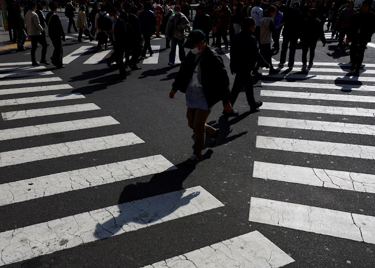 Passersby walk on a street in Tokyo, Japan, on February 15, 2024. An analyst says the economy will continue to lack momentum for the time being with no key drivers of growth. REUTERS/ISSEI KATO