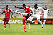 Horoya's Godfred Asante tries to block Justin Shonga of Pirates  during their CAF Champions League tie on Friday.   