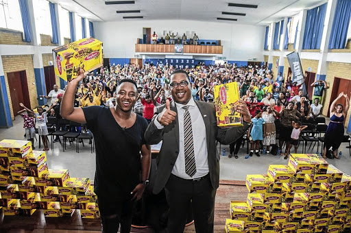 DJ Shimza and MEC Panyaza Lesufi happy about donation of school shoes.