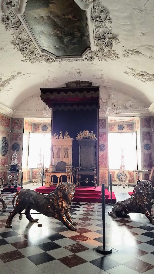 Visiting Rosenborg Castle in Copenhagen. On the third floor and is where you'll find the impressive Throne Room, also known as the Long Hall or Knights’ Hall. It was intended as a ballroom, and here you will find the coronation thrones for the king and queen and three life-size silver lions standing guard. On the other side of the room is displayed the throne for audience.