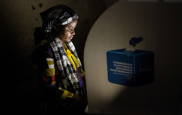 A voter marks her ballot paper in a booth at the Mavuno polling centre during the Presidential election in Goma, North Kivu province of the DRC on Wednesday.