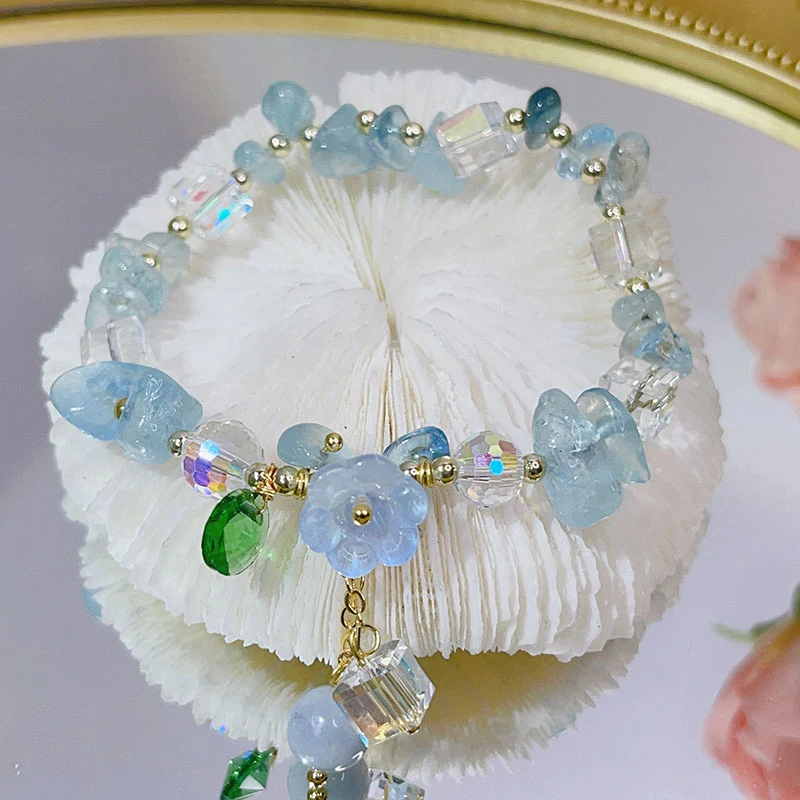 Pulseira Super Fada Cristal de Fluorita Roxa, Flor e Seixos Esmaltados em Aquamarine, elegância e espiritualidade em suas mãos.