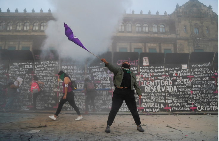 A woman waves a flag during a protest outside the National Palace on International Women's Day in Mexico City on March 8 2021.