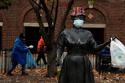 A bronze statue of late singer Ella Fitzgerald is seen wearing a hat and protective face mask, as the global outbreak of the coronavirus disease (COVID-19) continues, outside the Metro-North Railroad Station Plaza in Yonkers, New York, U.S., November 17 2020. 