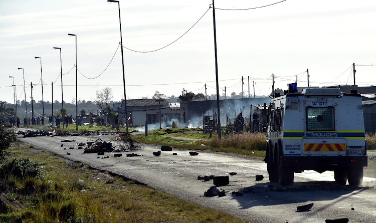 A rubble-strewn road in Kuyga where protests took place on Wednesday after partly built shacks were removed