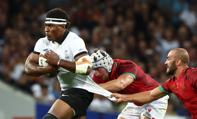 Fiji's Vinaya Habosi in action against Portugal's Samuel Marques and David Wallis de Carvalho in their Rugby World Cup Pool C match at Stadium de Toulouse on Sunday.