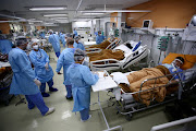 Medical workers take care of patients in the emergency room of the Nossa Senhora da Conceicao hospital that is overcrowding because of the coronavirus outbreak, in Porto Alegre, Brazil, March 11, 2021. 