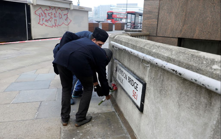 Sabah Ahmedi and Mansoor Clarke, imams of the Ahmadiyya Muslim Community, lay down flowers on November 30 2019 to mourn the victims at the scene of a stabbing on London Bridge, in which two people were killed, in London, Britain.