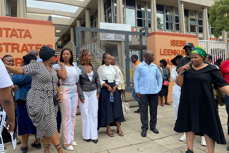 Doctor Yolisa Siphambo-Mngxali, fourth from left (wearing a white blouse and navy skirt) and her family outside the Mthatha magistrate’s court, flanked by supporters.