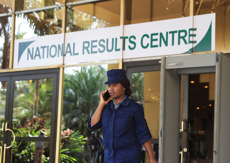 A Zimbabwe police officer talks on her mobile phone at the national results centre during vote counting for the general election. Picture: PHILIMON BULAWAYO/REUTERS