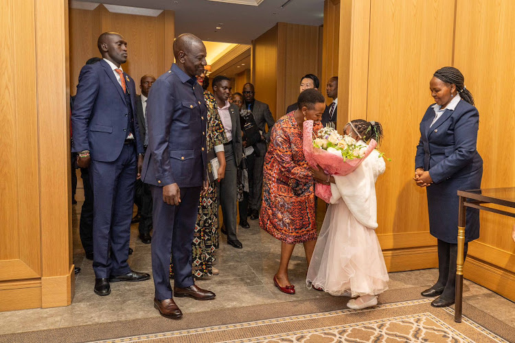 President William Ruto looks on as First Lady Mama Rachel Ruto receives a bouquet during an engagement with Kenyan diaspora in Tokyo during an engagement on February 7, 2024.