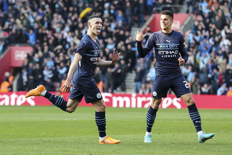 Phil Foden of Manchester City celebrates with teammate Joao Cancelo after he scores to make it 3-1 in the FA Cup quarterfinal against Southampton at St Mary's Stadium in Southampton on March 20 2022.