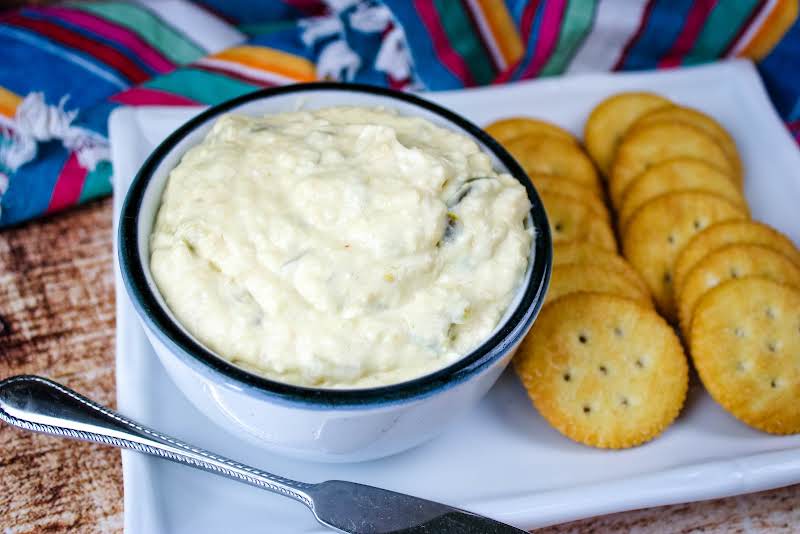 Warmed Jalapeno Cheese Spread In A Bowl With Crackers.