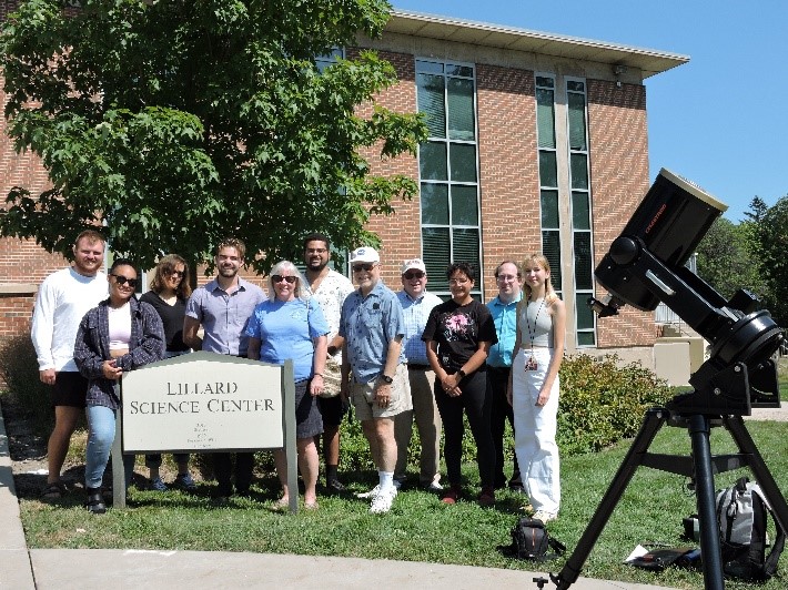 A group of people posing for a photo with a camera

Description automatically generated with medium confidence