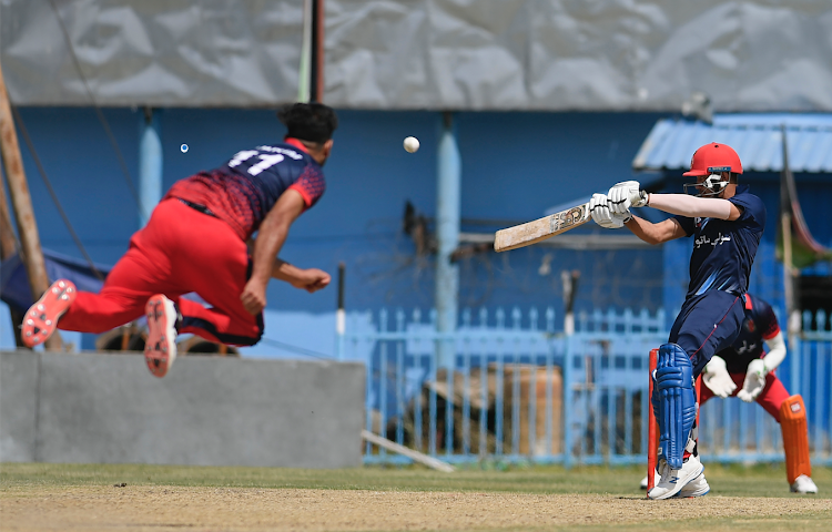 A Peace Defenders team player (R) plays a shot during the Twenty20 cricket trial match being played agianst Afghan team at the Kabul International Cricket Stadium in Kabul on September 3, 2021.