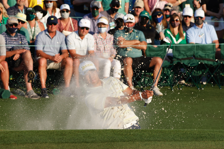 Japan's Hideki Matsuyama plays out from the bunker onto the 18th green during the final round